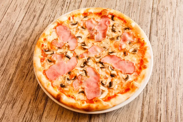 Pizza op houten ondergrond — Stockfoto