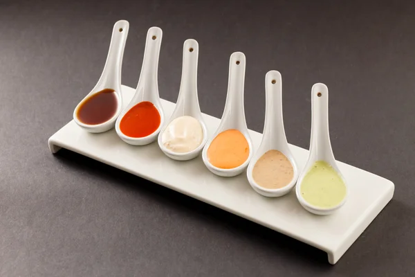 Assorted of sauces in spoons — Stock Photo, Image