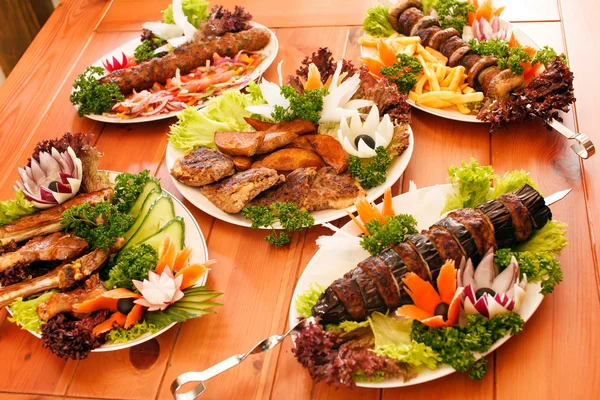 Piatti alla griglia su piatti in tavola — Foto Stock