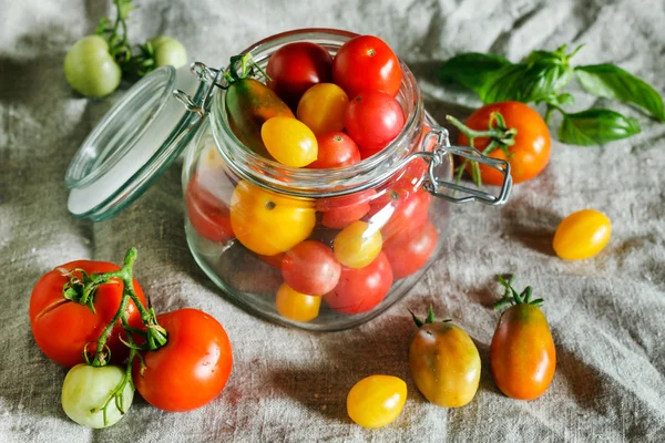 Colorful tomatoes in glass jar — Stock Photo, Image