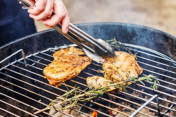 Man preparing chicken on barbecue — Stock Photo, Image