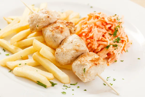 Chicken skewers with french fries — Stock Photo, Image