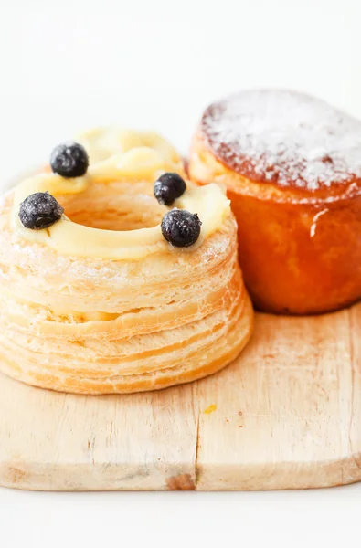 French pastries on wooden cutting board — Stock Photo, Image