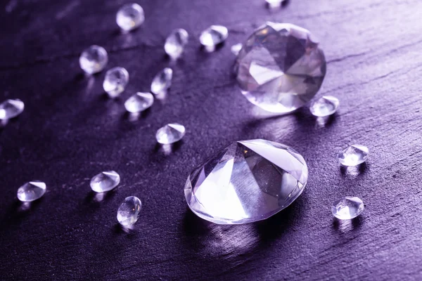 Různé diamanty s fialovým světlem — Stock fotografie