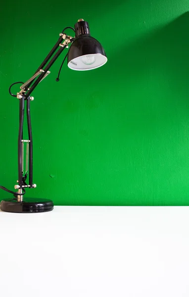 Lampada sul tavolo su verde — Foto Stock