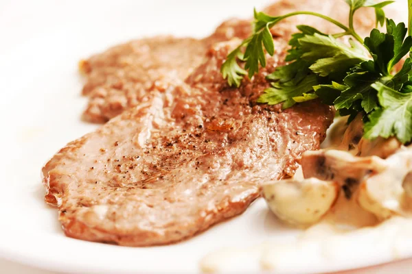 Meat with mushrooms on plate — Stock Photo, Image