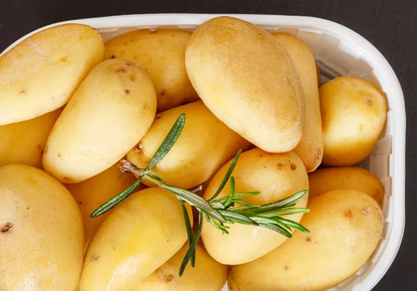 Potatoes tubers with rosemary — Stock Photo, Image