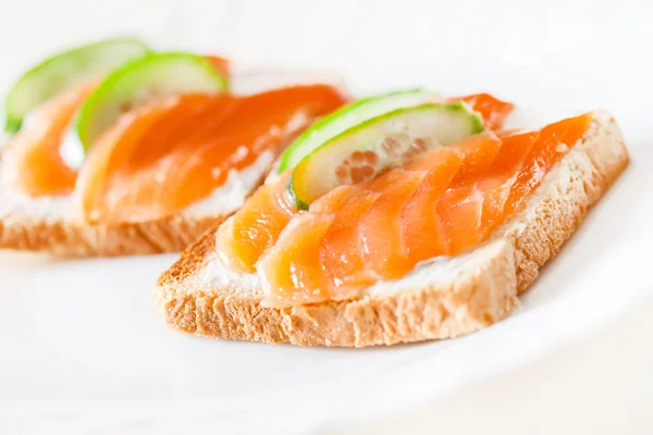 Toasts with salmon and cucumber slices — Stock Photo, Image