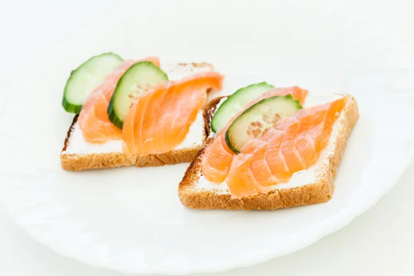 Toasts with salmon and cucumber slices — Stock Photo, Image