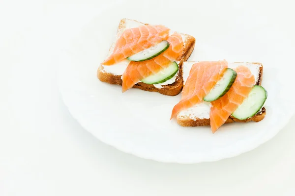 Toasts with salmon and cucumber slices — Stock Photo, Image