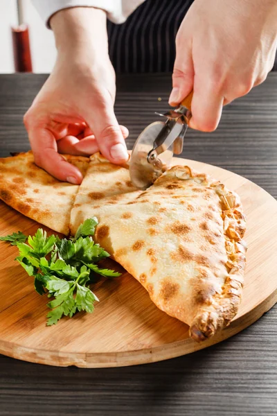 Styckning av Calzone pizza — Stockfoto