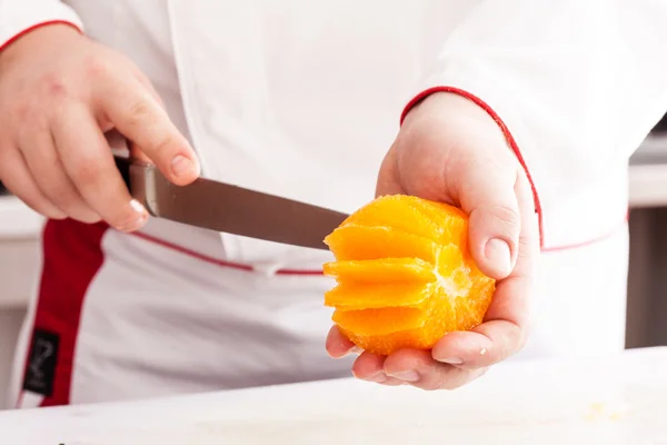 Chef cutting orange — Stock Photo, Image