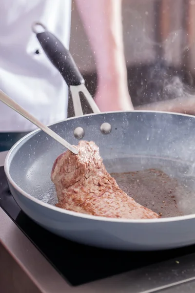 Chef-kok maken biefstuk op pan — Stockfoto