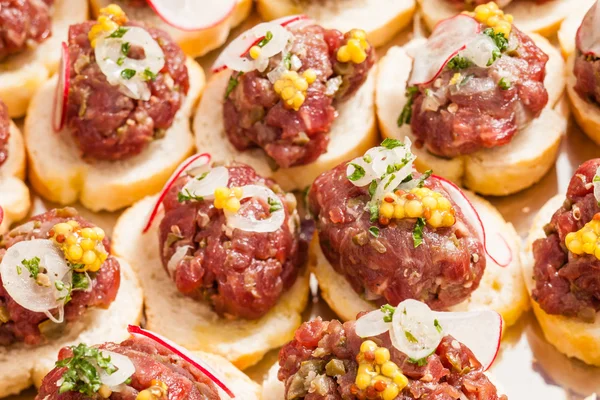 Canapes with meat on baguette slices — Stock Photo, Image