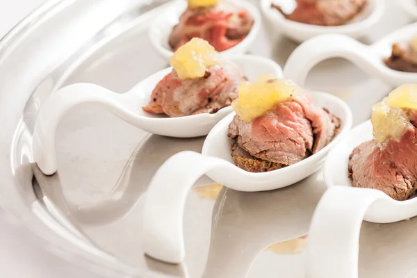 Meat appetizer on spoons — Stock Photo, Image