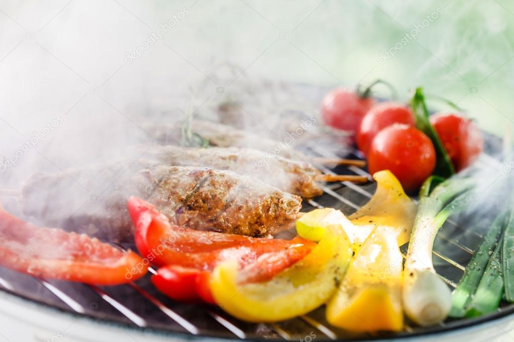 Kebabs with vegetables on grill