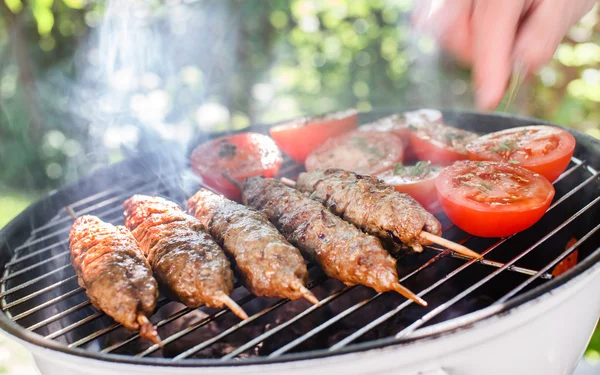 Grilling kebabs and tomatoes — Stock Photo, Image