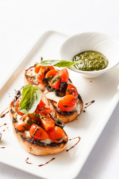 Bruschettas with tomato, mozarella and basil — Stock Photo, Image