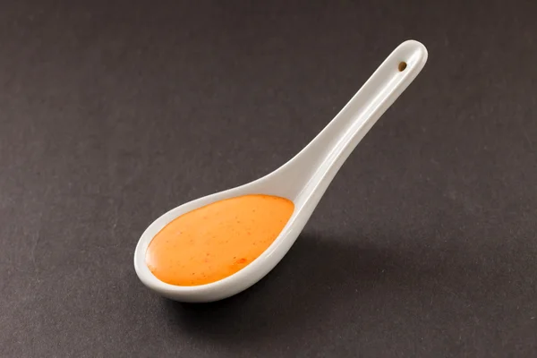 La salsa en la cuchara sobre negro — Foto de Stock