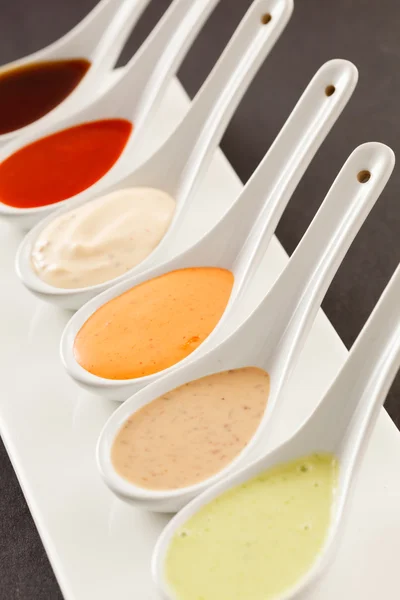 Assorted of sauces in spoons — Stock Photo, Image