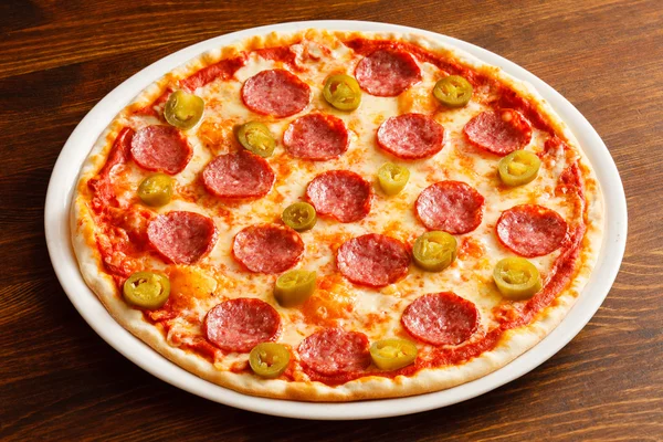 Heiße Pizza auf Holztisch — Stockfoto