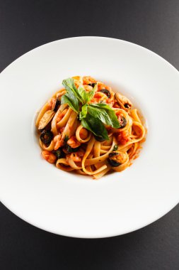 Fesleğen yaprakları ile deniz ürünleri makarna