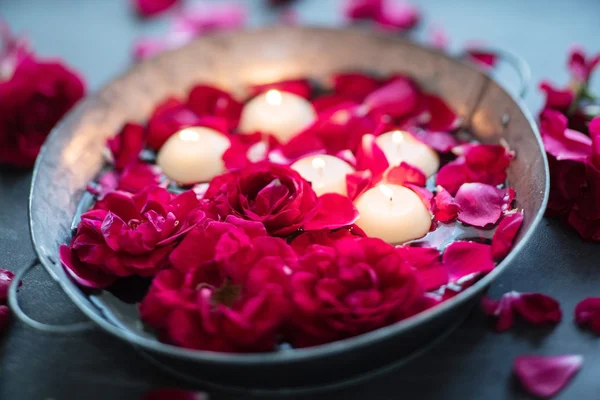 Rode rozen en kaarsen op water — Stockfoto