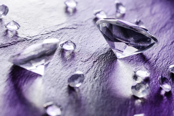 Different diamonds in purple light — Stock Photo, Image