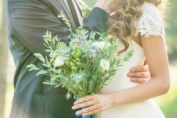 Brudgummen och bruden hålla blommor — Stockfoto