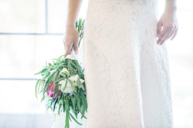 Gelin düğün buketi tutuyor.