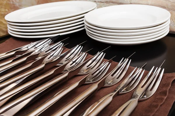 Forks and plates on table — Stock Photo, Image