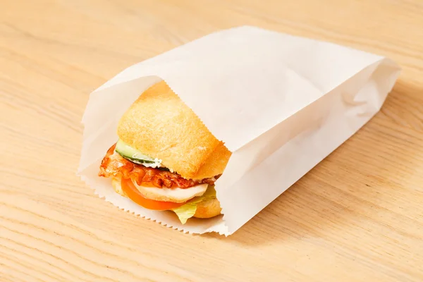 Tasty sandwich in paper bag — Stock Photo, Image