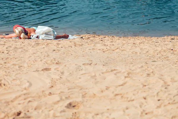 Kvinna liggande på stranden — Stockfoto