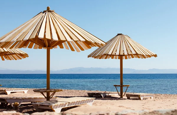 Beach with umbrellas and deckchairs — Stock Photo, Image