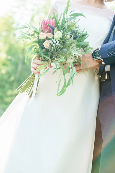 Groom and bride holding flowers — Stock Photo, Image