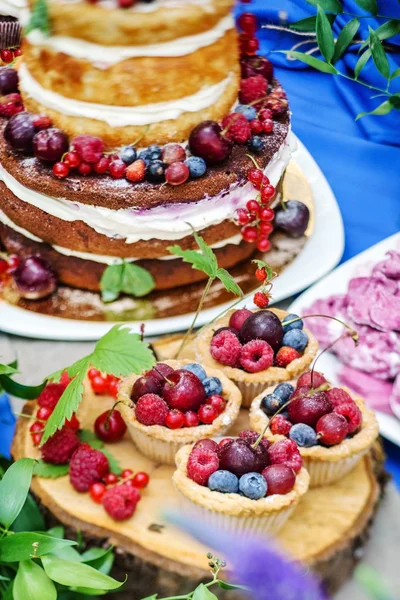Meztelen esküvői torta és cupcakes a bogyók — Stock Fotó