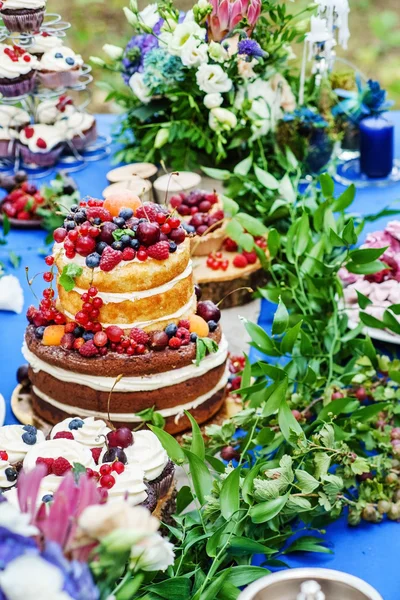 Naked wedding cake and cupcakes with berries — Stock Photo, Image