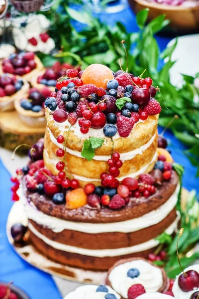 Pastel de boda desnudo y cupcakes con bayas —  Fotos de Stock