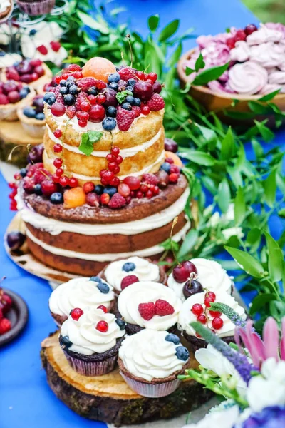 Naked wedding cake and cupcakes with berries — Stock Photo, Image