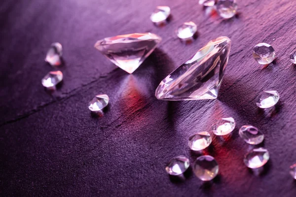 Different diamonds on purple background — Stock Photo, Image