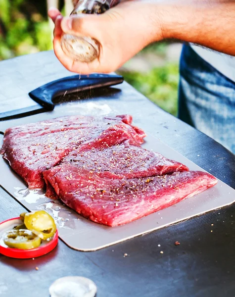 Kokki veistämässä ja marinoimassa lihaa — kuvapankkivalokuva