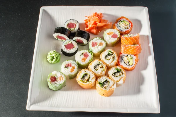 Saborosos rolos de sushi definidos na placa — Fotografia de Stock