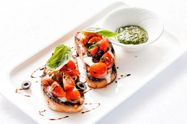 Bruschettas met tomaat, mozzarella en basilicum — Stockfoto