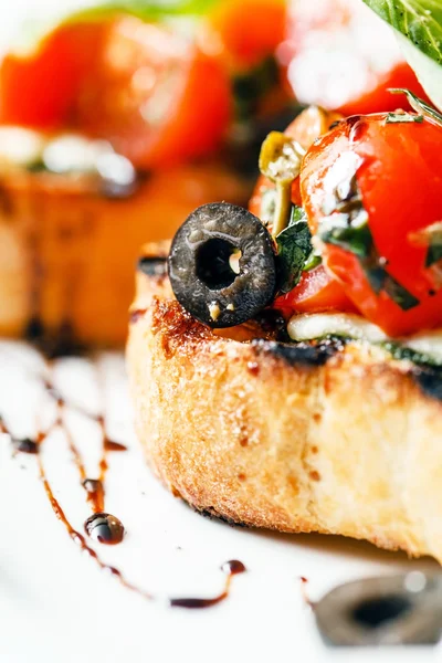 Bruschettas met tomaat, mozzarella en basilicum — Stockfoto