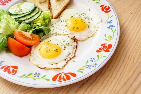 Fried eggs, toasts and fresh vegetables — Stock Photo, Image