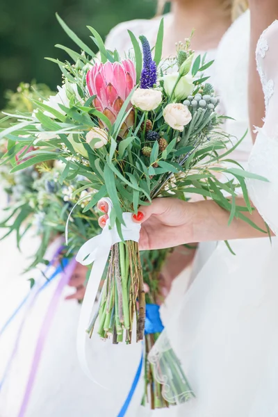 Sposa e damigelle d'onore che tengono fiori — Foto Stock