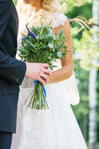 Γαμπρός και νύφη κρατώντας λουλούδια — Φωτογραφία Αρχείου