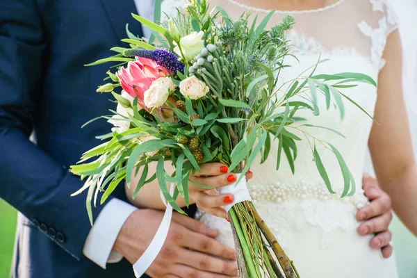 Ženich a nevěsta drží květiny — Stock fotografie
