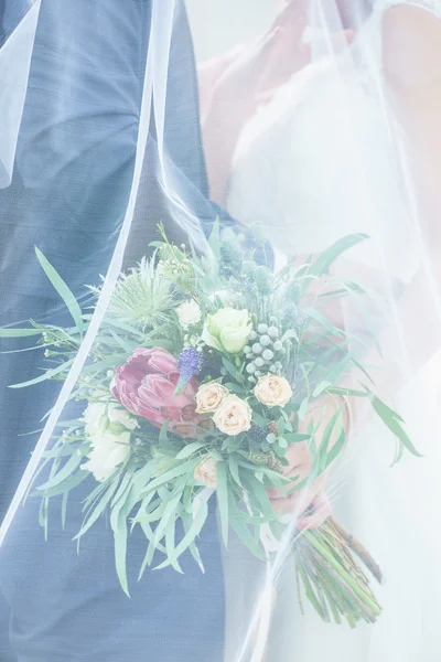 Γαμπρός και νύφη κρατώντας λουλούδια — Φωτογραφία Αρχείου