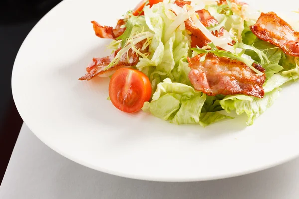 Salade avec bacon sur assiette — Photo